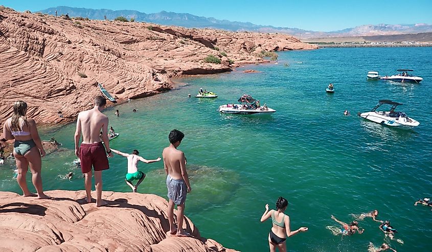 Young people jumping and diving from the rocks at Sand Hollow State Park.