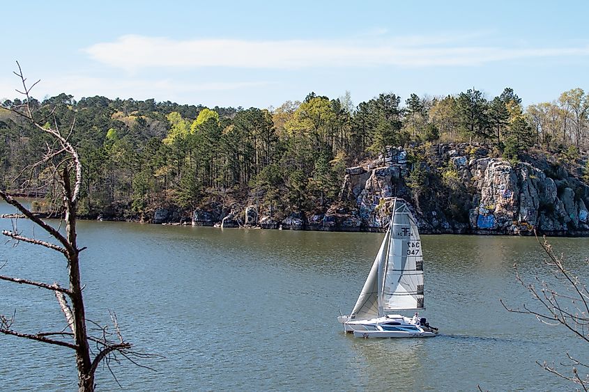 A sailboat floating past the rock formation known as Chimney Rock on Lake Martin, Alabama.