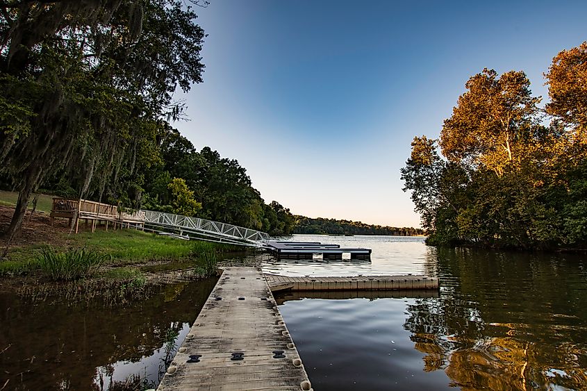 Floating docks at the boat ramp in Cooter’s Pond Park, Prattville, Alabama, extending into the Alabama River with a tree-lined shore in the background.