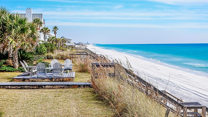 Deck and beach staircase leading to pristine white beach with blue water in Dune Allen, Florida.