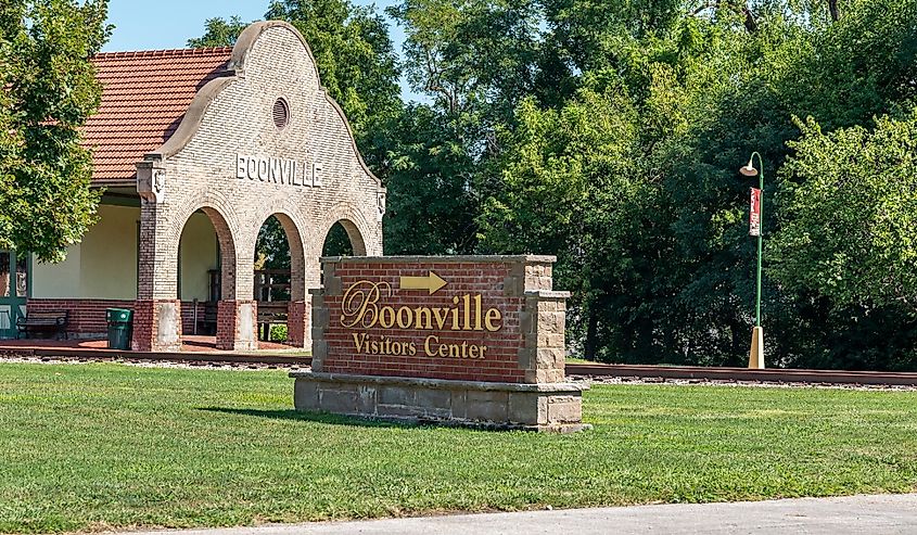 City of Boonville Visitor Center sign, with historic train depot in background.