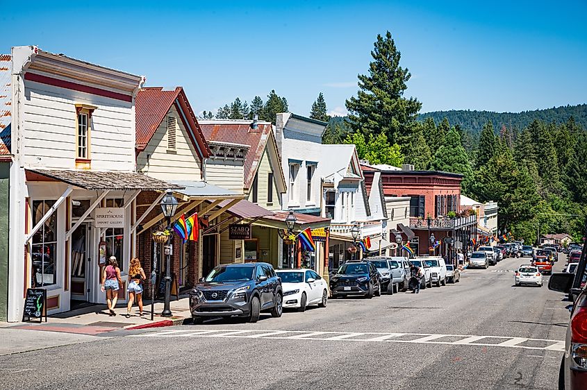 Shops and eateries along Broad Street with rainbow flags during Pride Month, Nevada City, CA, USA.