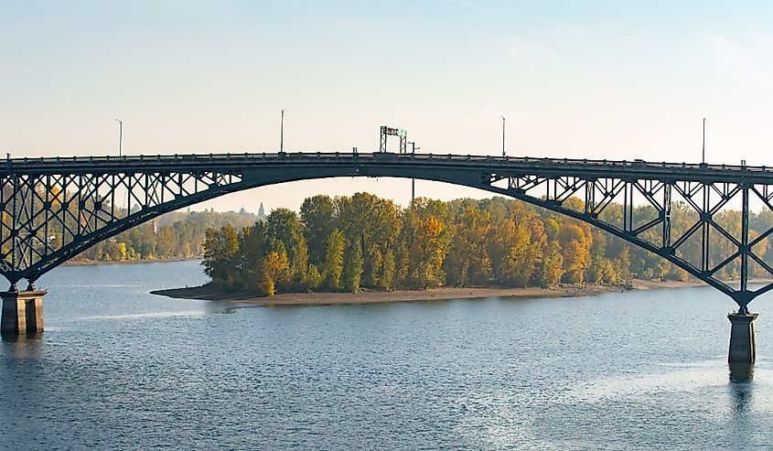 Ross island bridge in Portland, Oregon. Arc shaped cantilever truss bridge across Willamette river; connects east and west city sides.