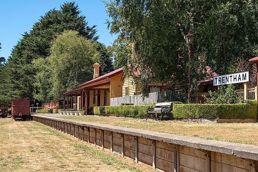 Historic building and the platform of Trentham railway station with some old carriages nearby.