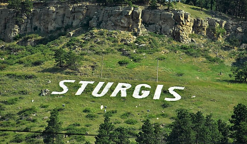 White Sturgis sign spelled out in the countryside welcoming visitors to the town.