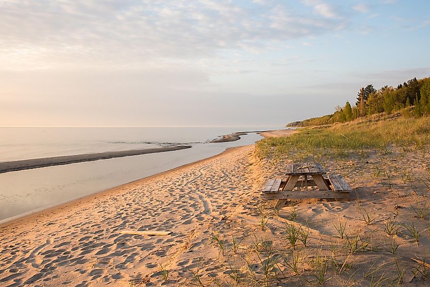 Twilight at Lake Michigan with a sandy beach, dune grasses, and a picnic table in Bridgman, Michigan.