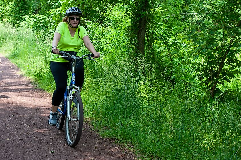  A Woman on a bicycle on a trail in Raritan-Delaware Canal State park in Somerset county New Jersey