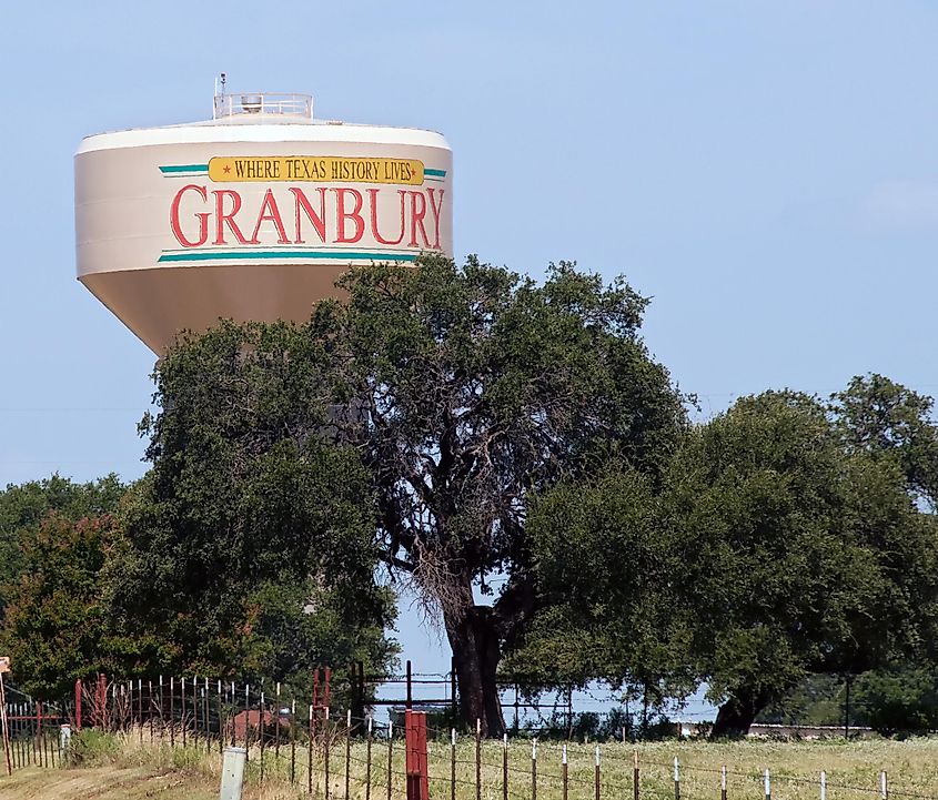 Composite Elevated Water Tower painted with the city slogan behind a cattle ranch.