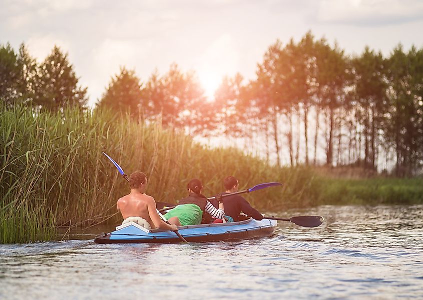 Young people kayaking on the calm waters of Cane River Lake