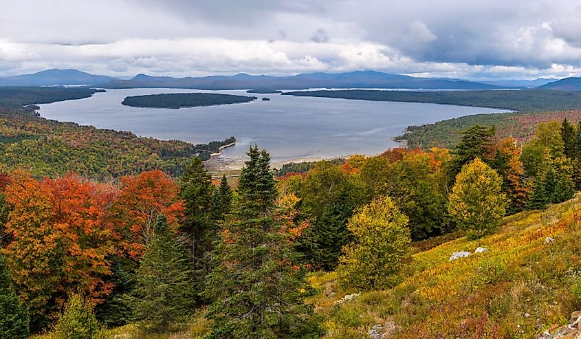 Height of Land - A panoramic overview of Mooselookmeguntic Lake and its surrounding rolling hills on a colorful but stormy Autumn day, as seen from Height of Land at side of Route 17, Maine