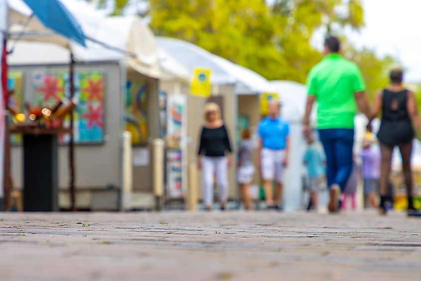 People walk around an art festival enjoying paintings and drawings