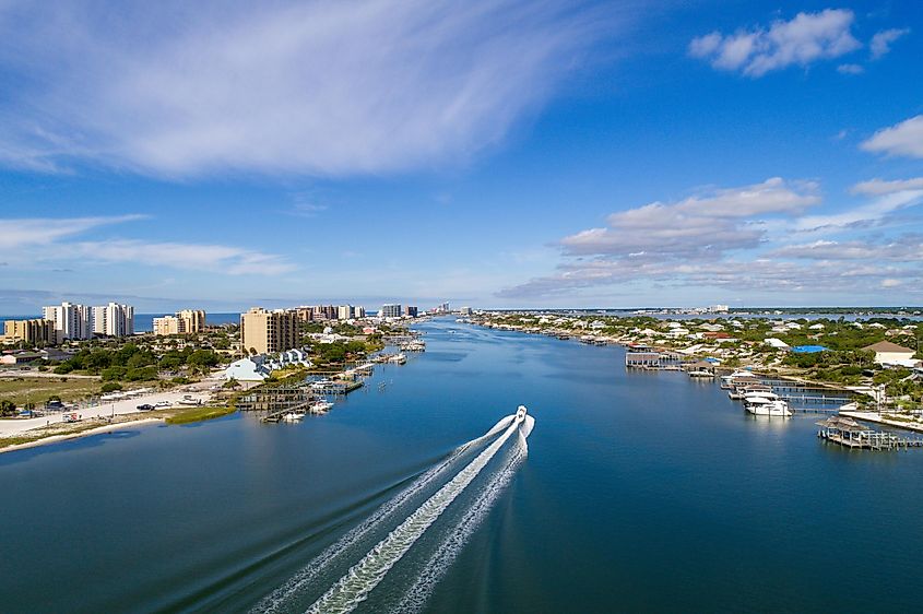 An aerial view of the boat driving on aqua water near Perdido Key Beach in Pensacola, Florida