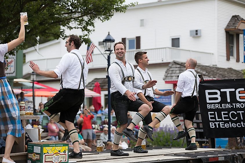 Frankenmuth, Michigan: Men and women playing traditional german music drinking beer dancing and wearing traditional german clothing at the Bavarian Festival Parade.