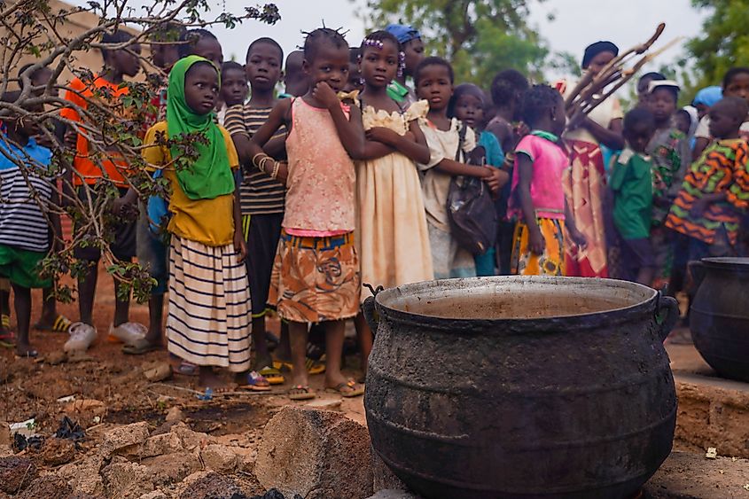 Burkina Faso: Children are waiting in line for food delivery. Poor nutrition negatively affects education. Shutterstock/Allowosman