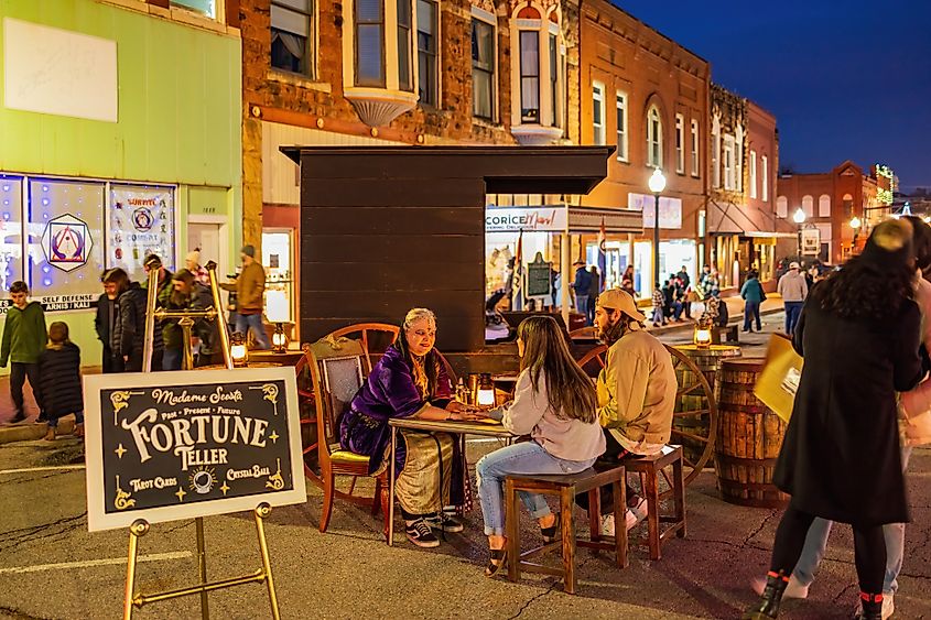 A fortune teller seated in a Victorian-style setting during the famous Guthrie Victorian Walk