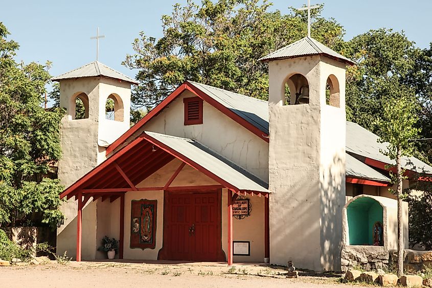 Rebuilt in 1973, historical white adobe walled Our Lady of Guadalupe Catholic church in Hillsboro, New Mexico