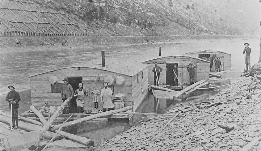 Pine Creek lumber drive, with arks for kitchen and dining (left), sleeping (center), and horses (right): the railroad is on the shore behind.
