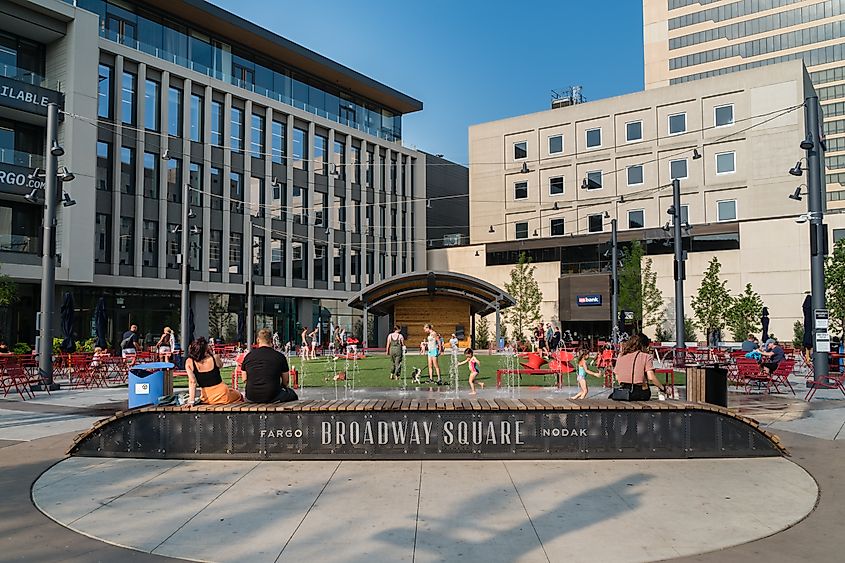 People gather around public fountain on a hot summer day at Broadway Square in West Fargo. Editorial credit: Heidi Besen / Shutterstock.com