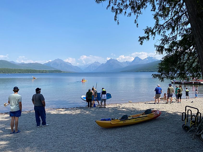 People of all ages waiting to launch their various paddle crafts into the calm waters of Lake McDonald.