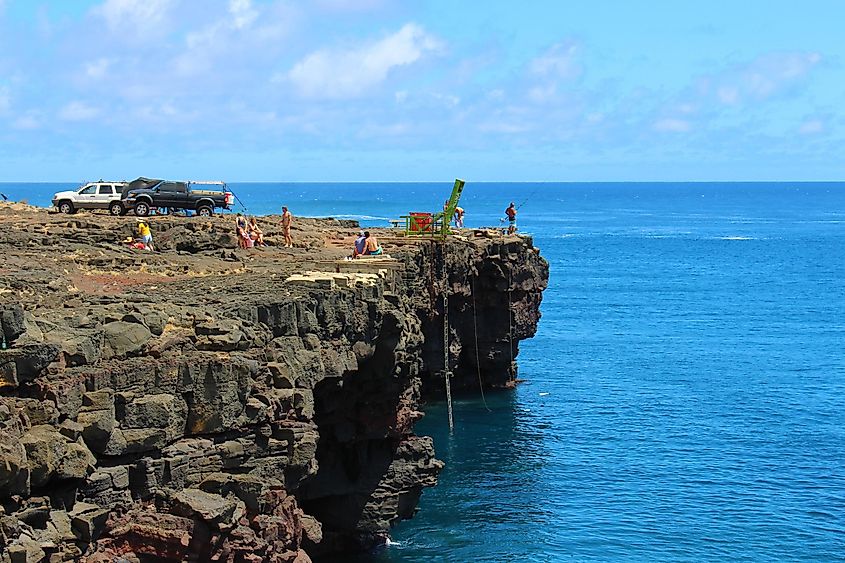 Tourists and local fishermen gather on the cliffs of South Point on a warm day to enjoy the Hawaiian sunshine in Naalehu. 