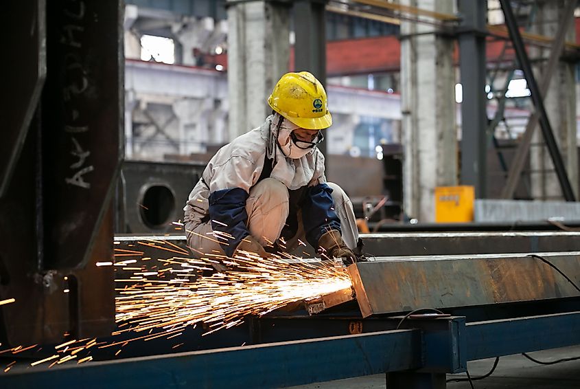 Workers lift steel to make a production order for steel box girders at the production workshop of China Railway Jiuqiao Engineering Co., LTD.