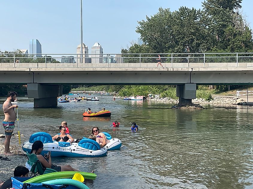 People aboard inflatable rafts float down the Elbow River in Calgary