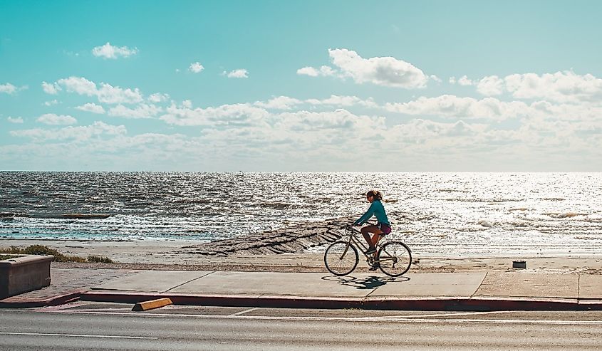 Woman riding her bicycle on Seawall Blvd. in Galveston, Texas.