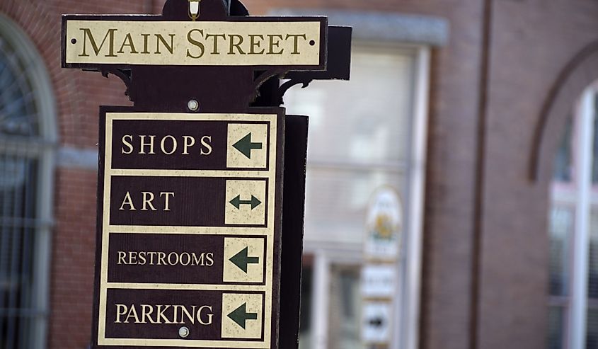 Main Street sign post, Berlin, Maryland, with brick building in soft focus in the background.