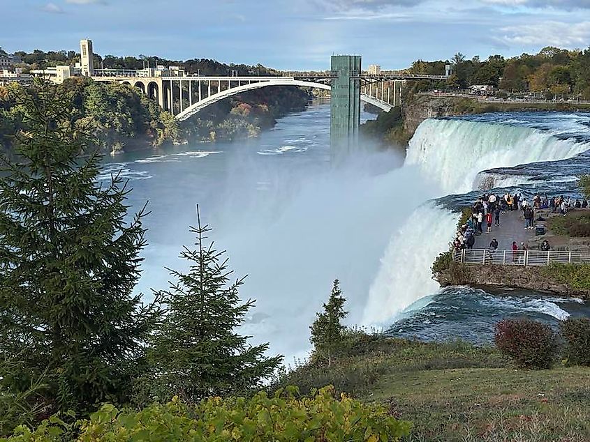 A sweeping view of Niagara Falls and the crowd gathered atop one of its misty lookouts.