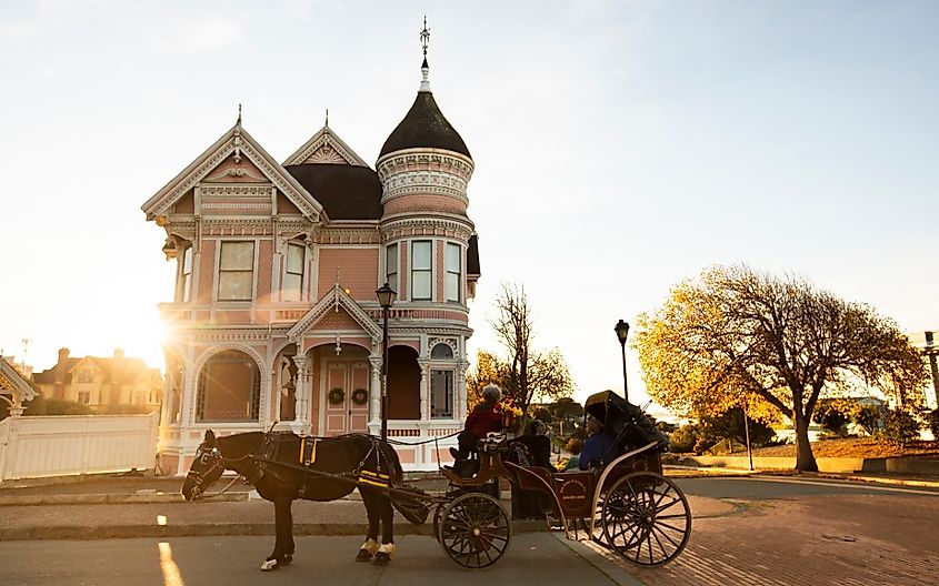 A horse and buggy stop in front of a historic Victorian home in downtown Eureka.