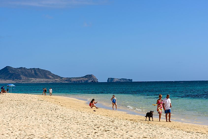 People along Lanikai Beach in Kailua, Hawaii.