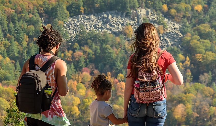 Young family looking at fall colors from top of west bluff at Devils lake state park in Wisconsin.