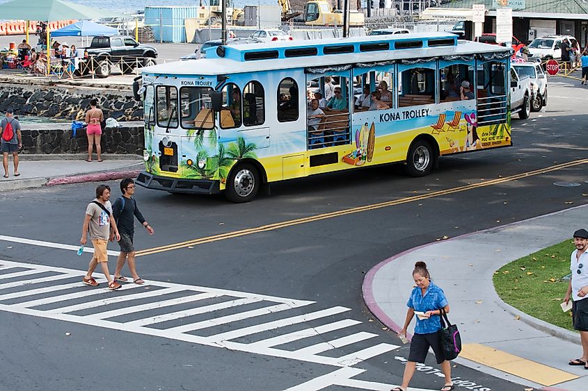 Trolley bus with tourists touring the Hilo Bay seawall on the Big Island, Hawaii during summer holidays