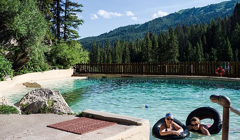 Two female friends enjoy Granite Creek Hot Springs in Jackson Wyoming with black inner tubes