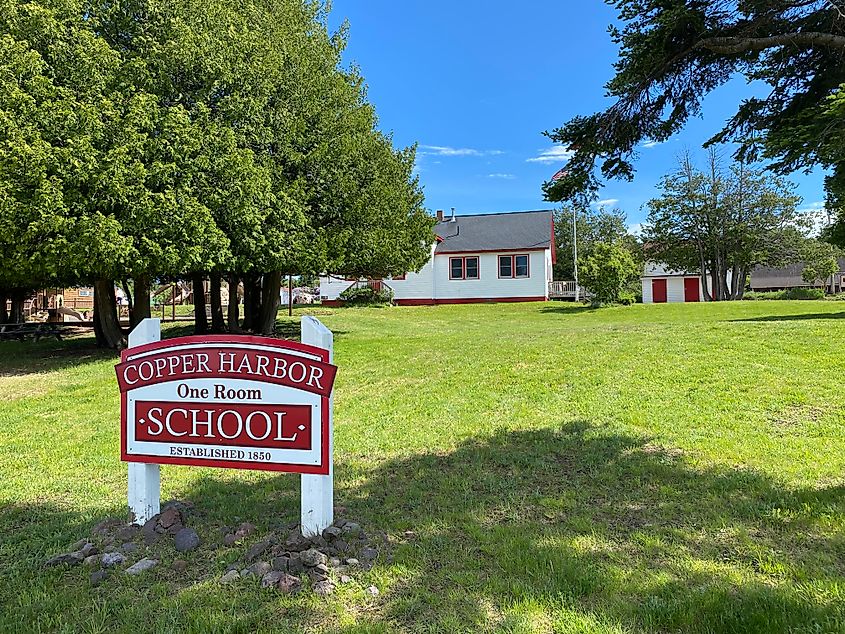 The red and white sign for the red and white Copper Harbor One Room Schoolhouse. 