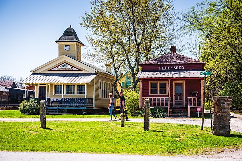 Couple walking past the Feed and Seed at Cackleberry Arch Park - Red Oaks II, Carthage, Missouri.