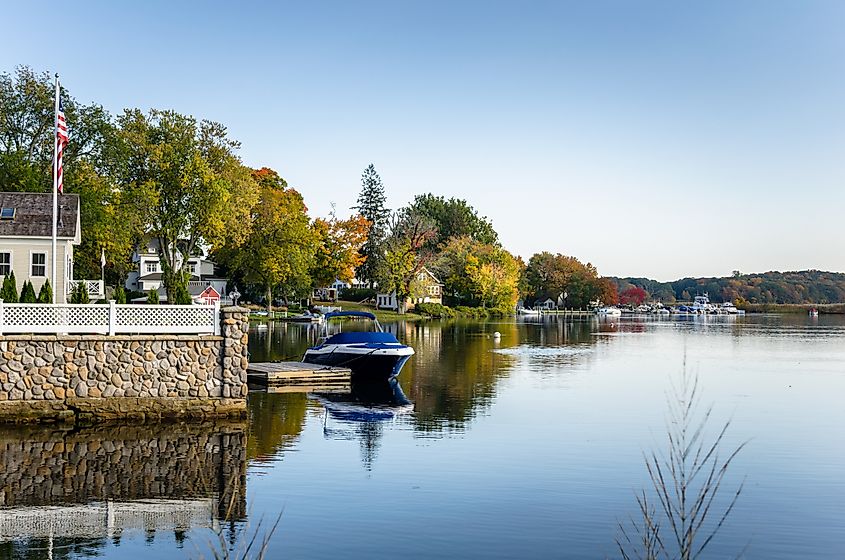 Waterside Houses among Trees with Boats Moored to Wooden Jetties on a Clear Autumn Day. Connecticut River, Essex, CT.