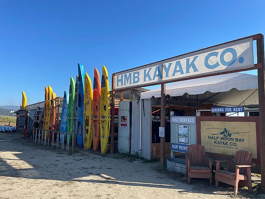 Colorful kayaks stand erect outside of a waterfront rental shop in Half Moon Bay, California. 