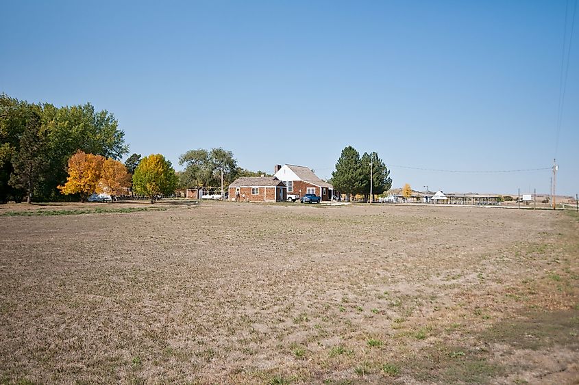 Ponca, Nebraska, with a house and surrounding outbuildings set amidst an open grassy field.