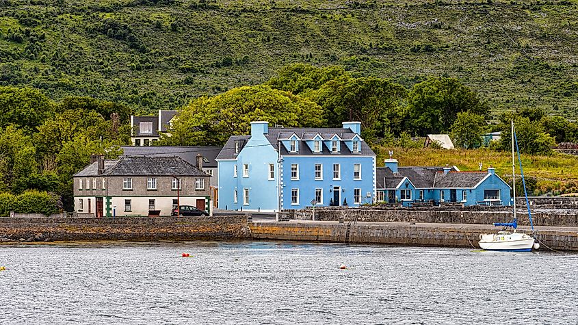 A blue house sits by the shore at Ballyvaughan, Ireland.