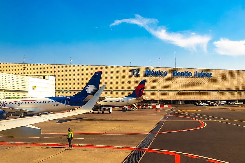 Aircraft at Benito Juarez International Airport with buildings and runway in Mexico City, Mexico. Image Credit Arkadij Schell via Shutterstock.