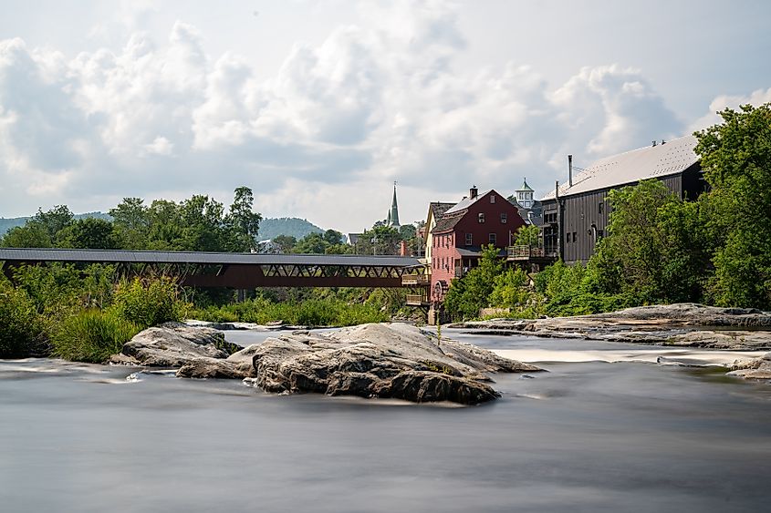 Littleton, New Hampshire, featuring the Riverwalk Covered Bridge spanning the Ammonoosuc River, captured in a long exposure photo.