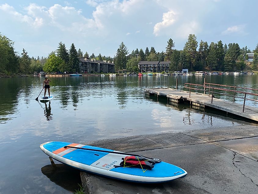 A female paddleboarder doing the last couple strokes to reach the dock.