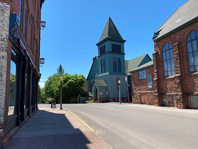 A sunny crossroads with three distinct and restored structures at the start of Historic Calumet Village 