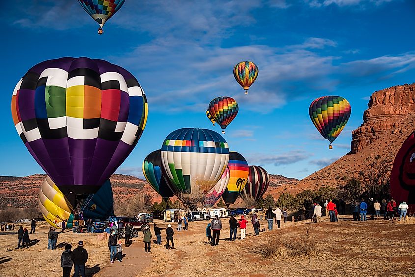 Spectators gathered in open fields beneath striking red rock mesas in Kanab, Utah