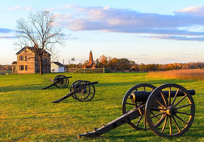 Historic Henry House and cannons at Manassas National Battlefield Park during sunset.