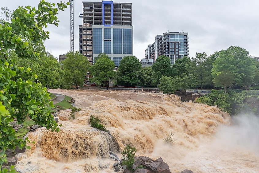 Reedy River in Greenville South Carolina flooding banks after days of rain in the city. Via Shutterstock / John Neff