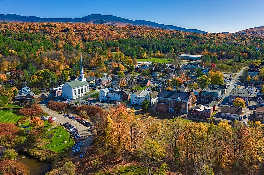 Aerial view of Stowe, Vermont, with colorful fall foliage and mountains.