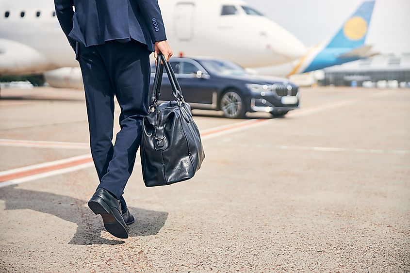 Cropped photo of a well-dressed man with a duffel bag, preparing for a business trip.