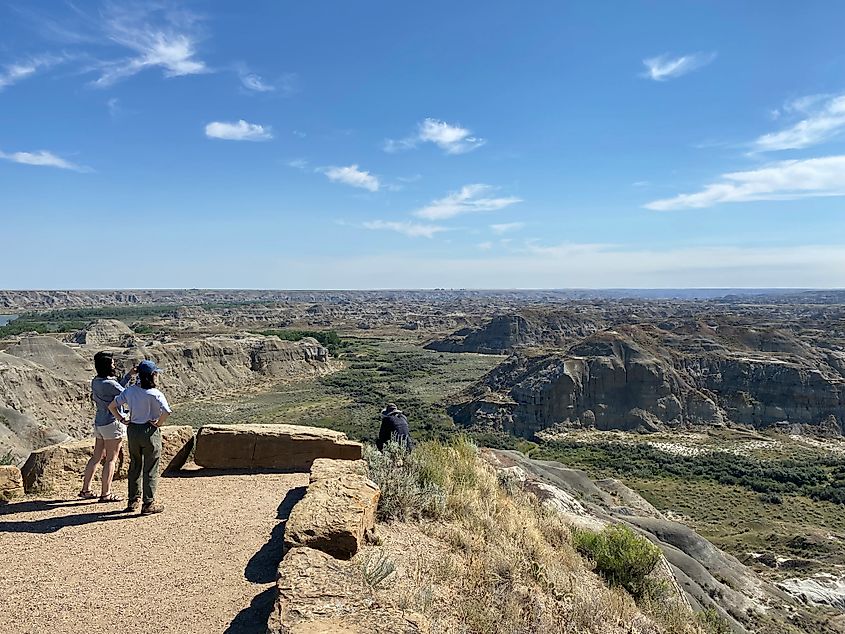 An Asian family takes photos from atop a panoramic badlands lookout.